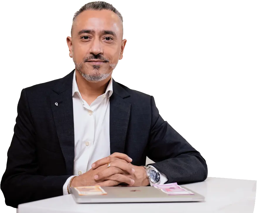 Dr Ameet Parekh sitting at a table with a laptop.